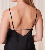 Close-up back view of model wearing the Triumph Silky Sensuality black nightdress, highlighting the lace-trimmed neckline and fluid, shimmering fabric. Available for Online Purchase