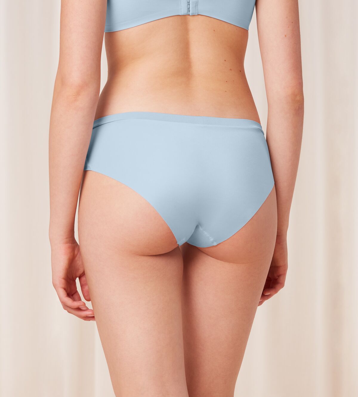 Triumph Body Make-Up Soft Touch light blue hipster panty model back view, highlighting the seamless finish and soft fabric. Available Online at Blue Salon Qatar
