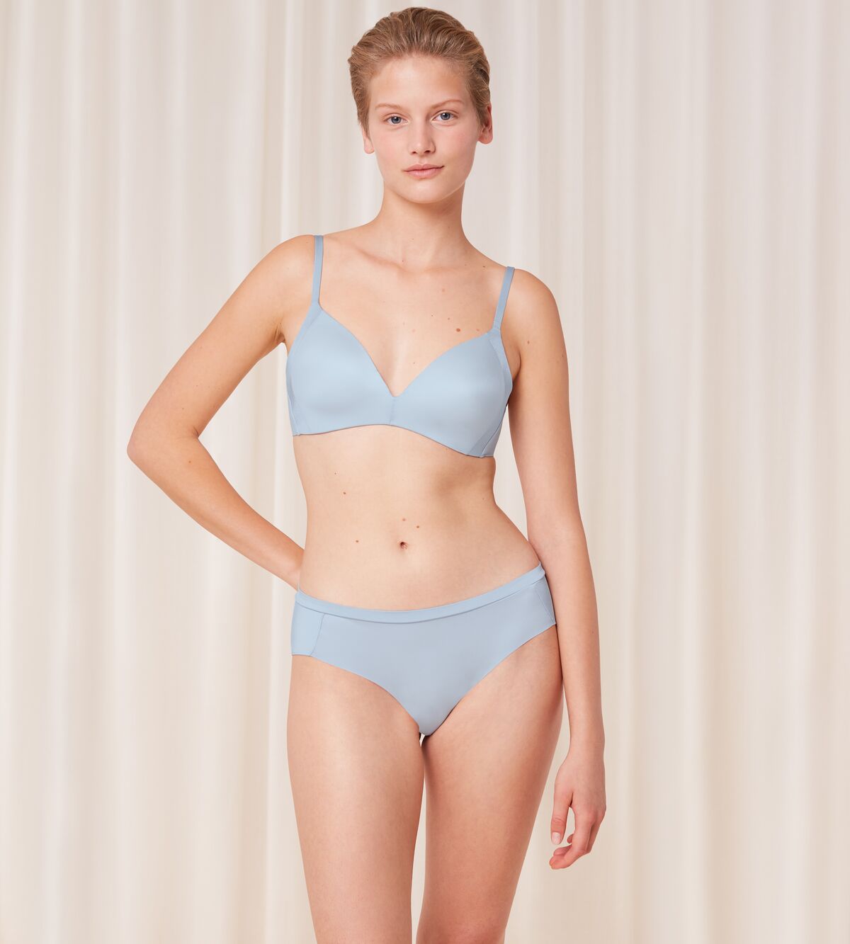 Triumph Body Make-Up Soft Touch light blue hipster panty model full front view, highlighting the seamless finish and soft fabric. Available Online at Blue Salon Qatar