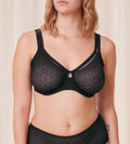 Triumph Signature sheer black minimizer bra model front view, with geometric monogram pattern. Available for Online Purchase